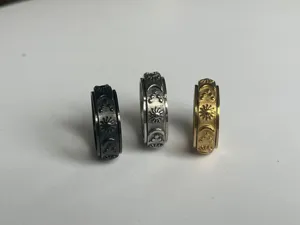 Vista dettagliata di anelli rotanti con motivi di sole luna e stella in nero argento e oro.