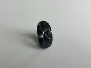 Anello antistress nero in acciaio inossidabile con motivo sole luna e stelle dettaglio.