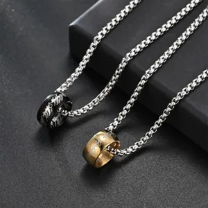 Gros plan détail de collier de couple en acier titane avec pendentif anneau et inscription.