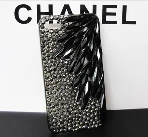Detailed close-up of sparkling rhinestone phone case featuring elegant black crystal drop details.