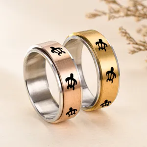 Vue de détail en gros plan de la bague couple en métal 8mm avec motif tortue rotatif.