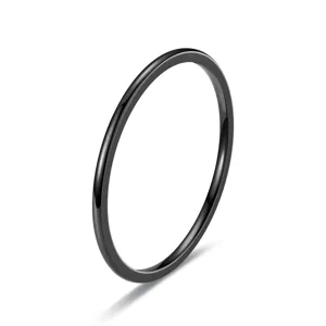 Detalle de anillo fino negro minimalista, acabado liso elegante, primer plano de joya.