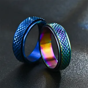Gros plan de bagues anti-stress en acier titane avec motifs diamant texturés, bleu et arc.