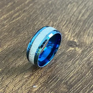 Bague en acier inoxydable bleu avec incrustation texturée et bords biseautés détaillés.