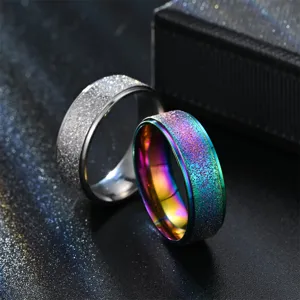 Close-up detail shot of matte finish titanium steel couple rings in silver and rainbow styles.