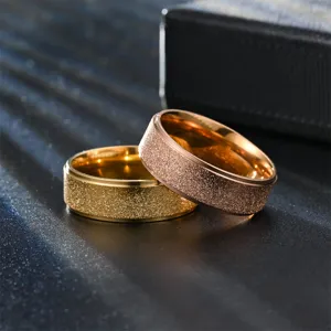 Detailed shot of titanium steel frosted couple rings, elegant gold and rose gold design.