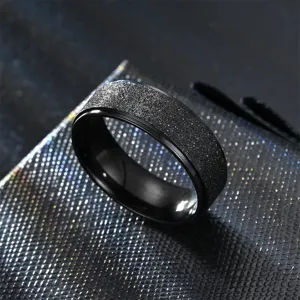 Detailed close-up of a stylish black matte titanium steel ring with glittering texture for couples.