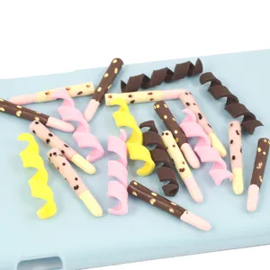 Primer plano detallado de bastoncillos de chocolate de arcilla polimérica y rollos para manualidades.