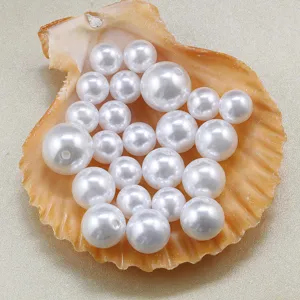 Close-up of white imitation pearl beads inside a natural seashell for DIY jewelry crafting.
