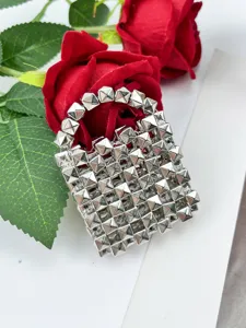 Detalle de mini bolso de mano de metal con tachuelas piramidales, accesorio de moda elegante y chic.