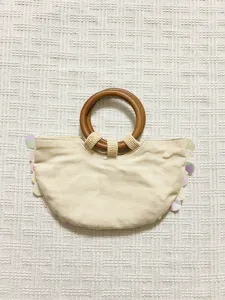 Chic spring summer handbag with wooden ring handle, beaded accents and iridescent sequin trim.