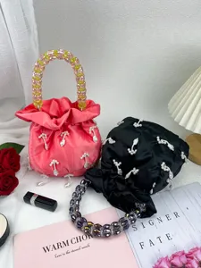 Sac seau en satin élégant doté de poignées de perles colorées et de pendentifs délicats.
