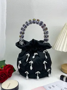 Vue détaillée du sac seau en satin noir avec pendentifs en perles et poignée en cristal.