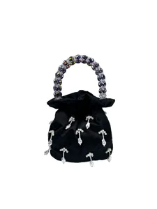 Détail de sac de soirée en satin noir avec poignée en perles de cristal et pendentifs.