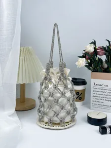 Gros plan du sac seau en filet de strass français avec poche en satin, élégant sac de soirée.