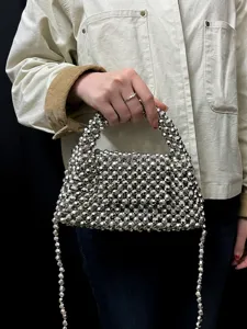 Nahaufnahme einer silbernen Acryl handgefertigten gewebten Perlen-Handtasche mit Kette.