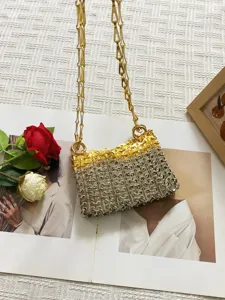 Dettaglio borsa a tracolla in metallo dorato e argentato, mini borsa a catena chic