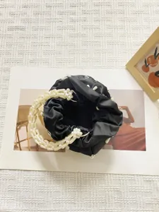 Schwarze Satin-Eimerkiste mit Perlenperlen-Griff und stilvollem Abendhandtaschendesign.