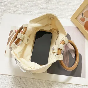 Stylish canvas handbag with wooden ring handles and unique sequin details for summer.