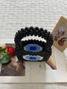 Handmade beaded handbag with unique evil eye design, trendy black woven tote bag for women.