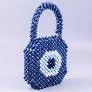 Vue détaillée du sac à main en perles d'acrylique bleu fait main avec motif œil turc.