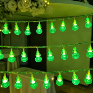 Close-up detail of glowing green gourd LED string lights, ideal for ambient decor and cozy setups.