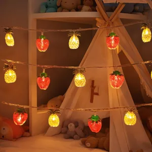 Decorative LED strawberry and pineapple string lights for cozy bedroom and party ambiance.