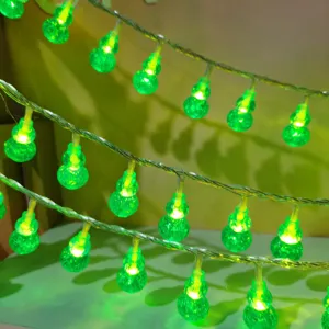 Close-up detail of green gourd LED string lights glowing brightly for cozy ambient room decor.