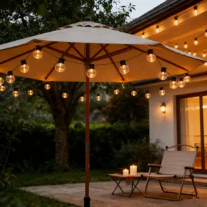 Outdoor LED solar globe string lights glowing warm in courtyard patio umbrella night scene.