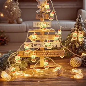 Close-up detail of glowing LED snowman string lights wrapped on a wooden Christmas tree decor.