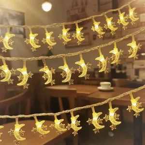 Close-up detail of LED moon and star string lights with warm glow for cozy room and holiday decor.