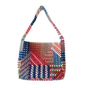 Détail de sac à main en perles fait main, montrant un motif tissé exquis et des couleurs vibrantes.
