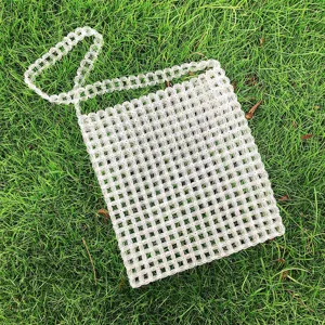 Dettaglio di perline trasparenti della borsa a tracolla in acrilico intrecciata a mano.