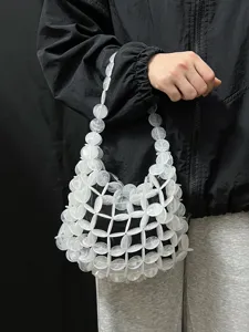 Gedetailleerd overzicht van de witte kralen tas, met het verfijnde opengewerkte design.