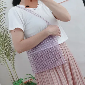 Dettaglio borsa a tracolla di perline trasparenti, design intrecciato a mano in acrilico donna.
