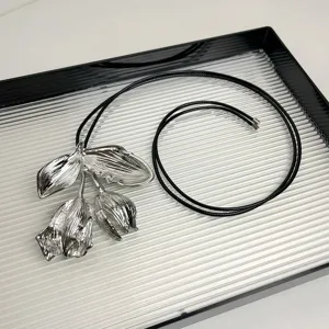 Detailaufnahme der silbernen Metallblumen Anhänger Kette mit schwarzem Lederseil.