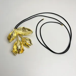 Detailansicht der goldenen Metallblumen Anhänger Halskette mit langem schwarzen Lederband chic