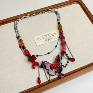 Primo piano dettagliato della collana girocollo con perline di farfalla rosa rossa punk.