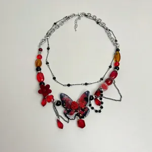 Collana girocollo con perle farfalla rosa rossa punk, doppia catena argentata e pendenti.