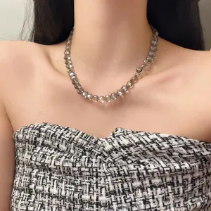 Close-up detail van transparante grijze hartvormige kralen choker halsketting, elegante stijl.