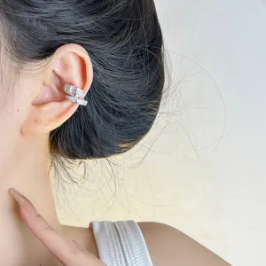 Nahaufnahme einer silbernen Schlangen Ohrklemme mit funkelnden Zirkonia Steinen.