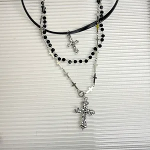 Dettaglio collana punk multistrato, con pelle nera, catene di perline e croci vintage.