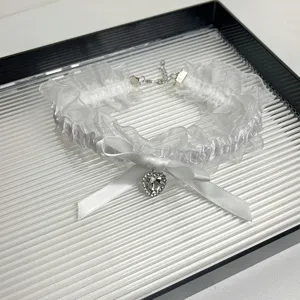 White lace choker necklace with satin bow and rhinestone heart pendant for women.