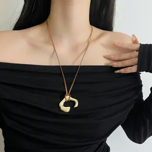 Stylish brown leather cord necklace with a unique irregular gold pendant for women.