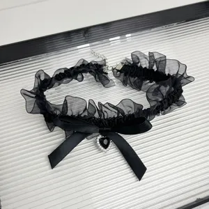Black lace choker necklace with bow and rhinestone heart pendant, gothic sweet jewelry detail.