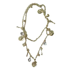 Catena da vita vintage dorata con ciondoli multipli tra cui sole e cristalli lucidi.