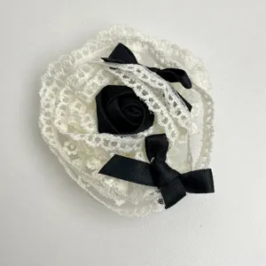 Vue détaillée de la broche fleur de rose en dentelle française avec un élégant ruban noir.