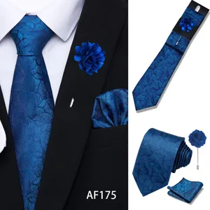 Detailed view of men's blue floral jacquard tie set, pocket square, and lapel pin.