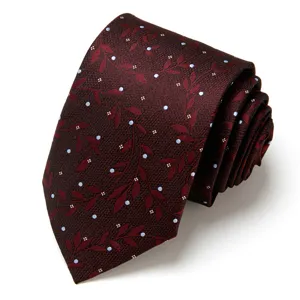 Detail of burgundy men's tie with elegant leaf and dot jacquard pattern for formal wear.