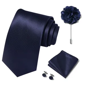 Vista detallada del juego de corbata para hombre azul marino con pañuelo, flor y gemelos.